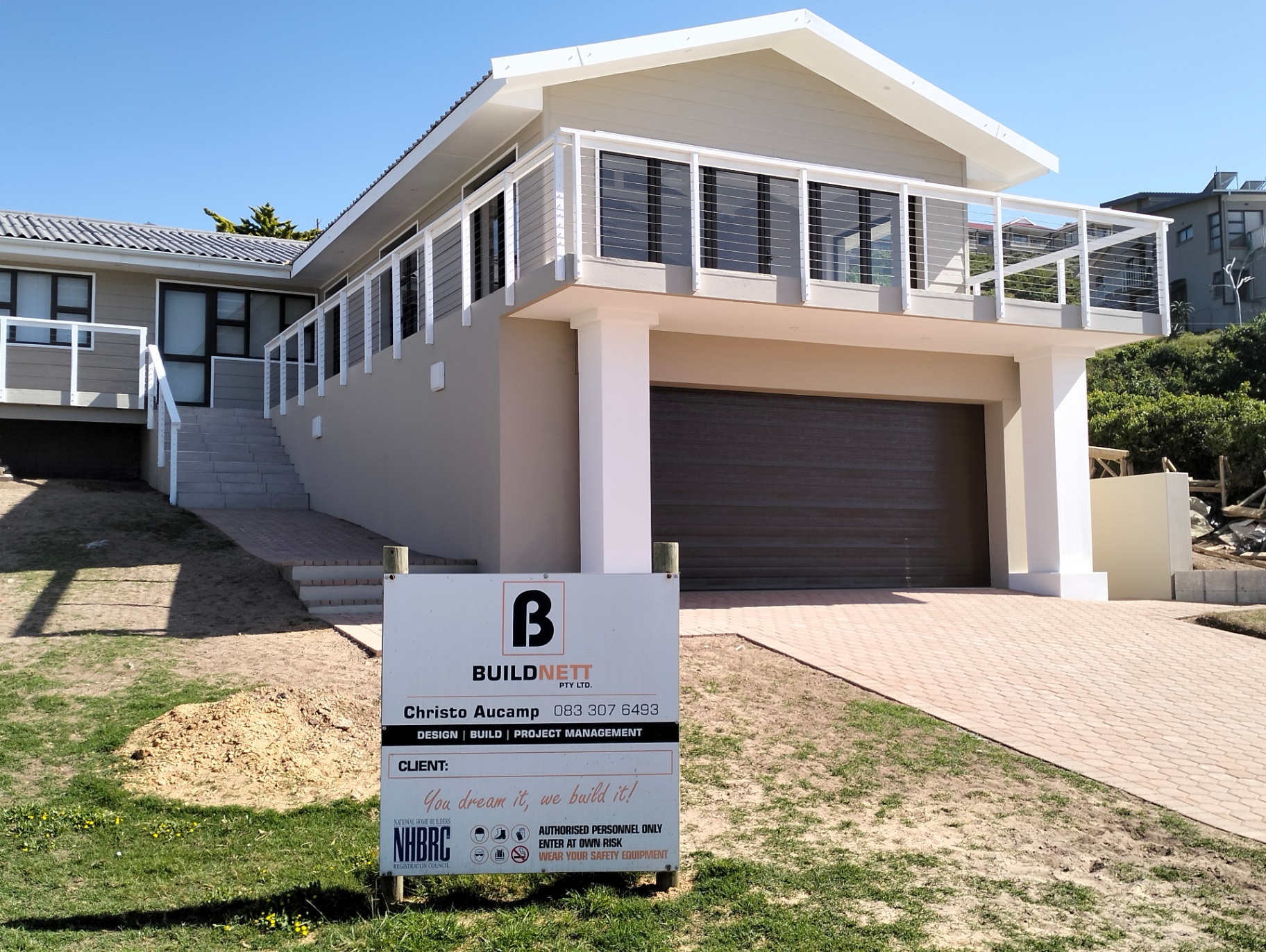 Completed elevated home with BuildNett project board