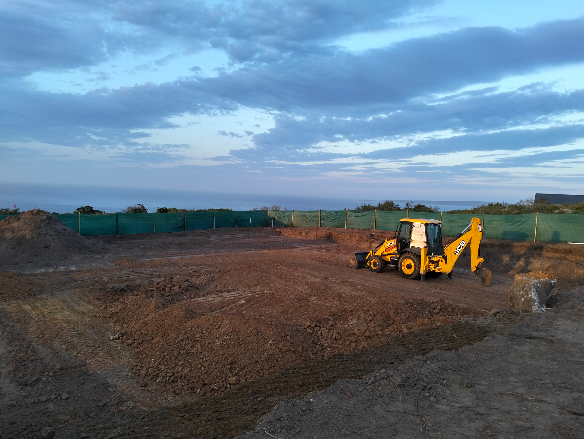 Site preparation with JCB and sea view
